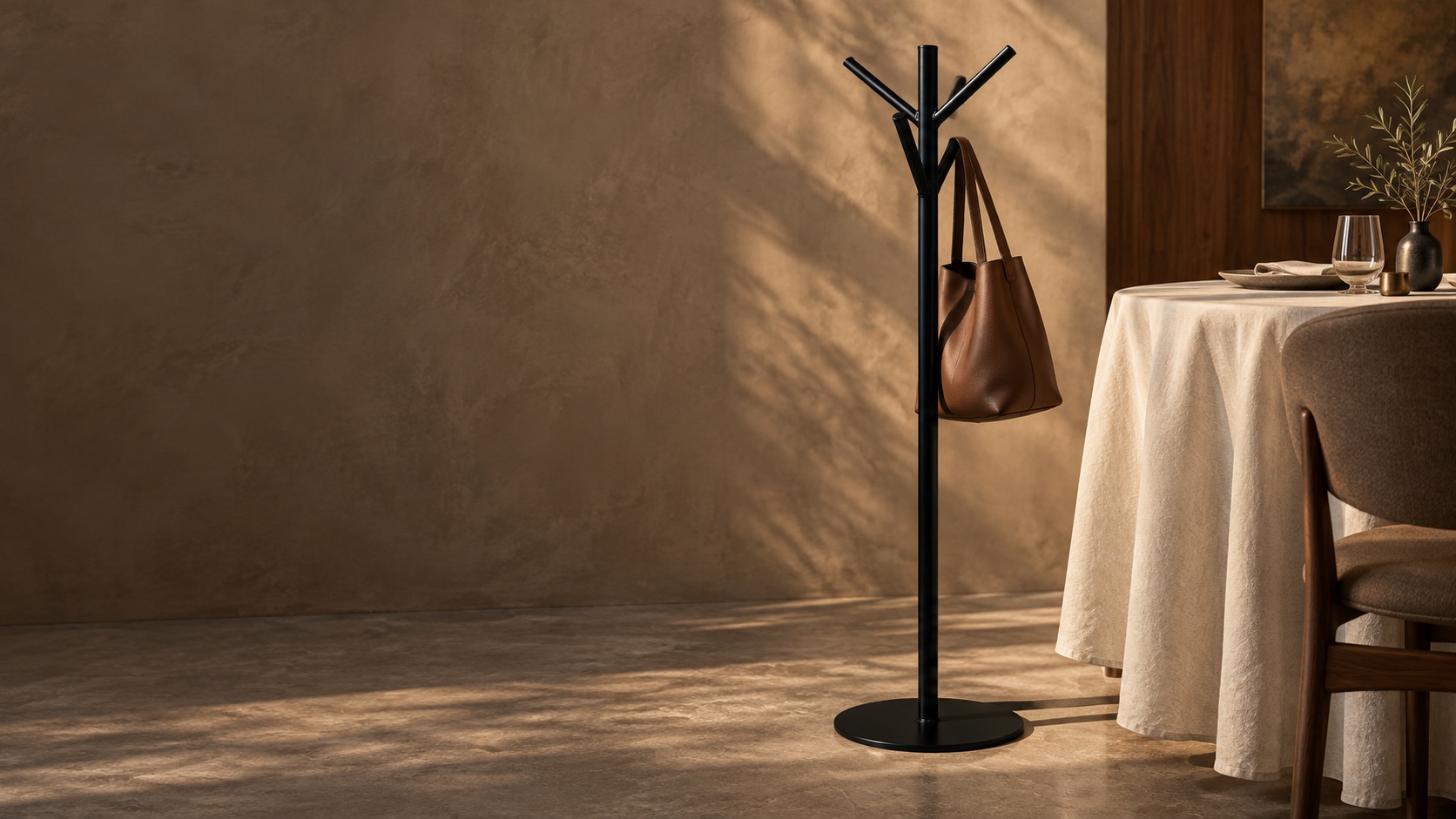 Concept visualization of a black tableside rack beside a linen-covered dining table, holding an unbranded handbag.